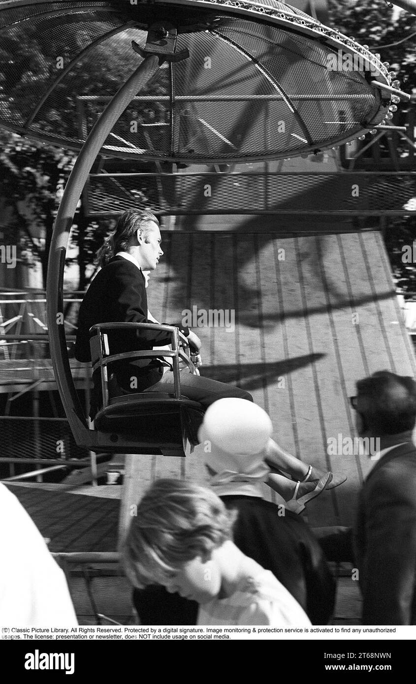 Parco divertimenti negli anni '1960 Una coppia e' vista in una delle attrazioni che vengono offerte sul terreno. Si siedono uno accanto all'altro in un posto che si muove intorno a sé. Svezia 1968 Foto Stock