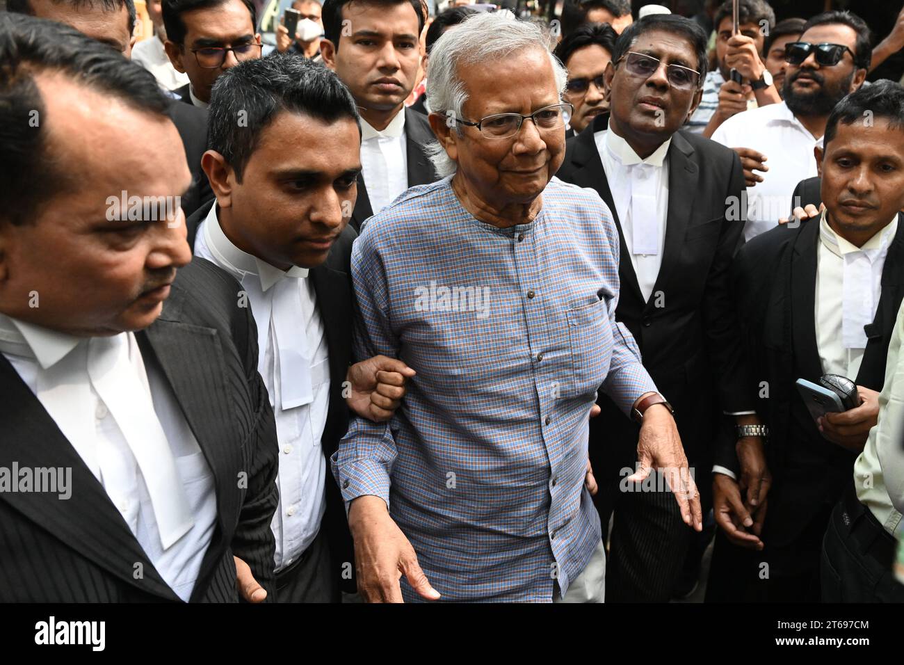 Il premio Nobel Muhammad Yunus (C) arriva con i suoi avvocati per un'udienza presso il tribunale del lavoro di Dacca, Bangladesh, il 9 novembre 2023. Foto Stock