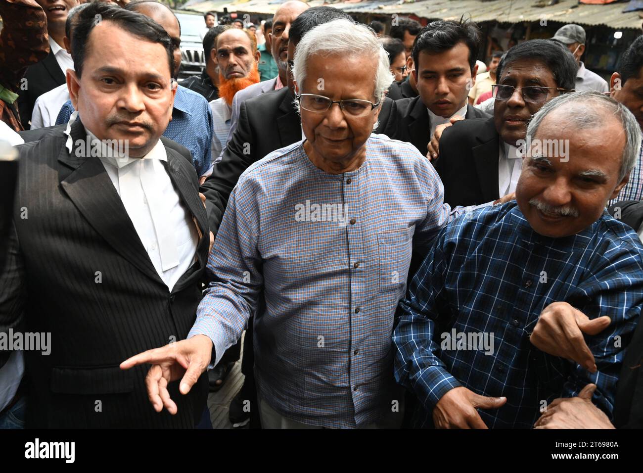 Il premio Nobel Muhammad Yunus (C) arriva con i suoi avvocati per un'udienza presso il tribunale del lavoro di Dacca, Bangladesh, il 9 novembre 2023. Foto Stock