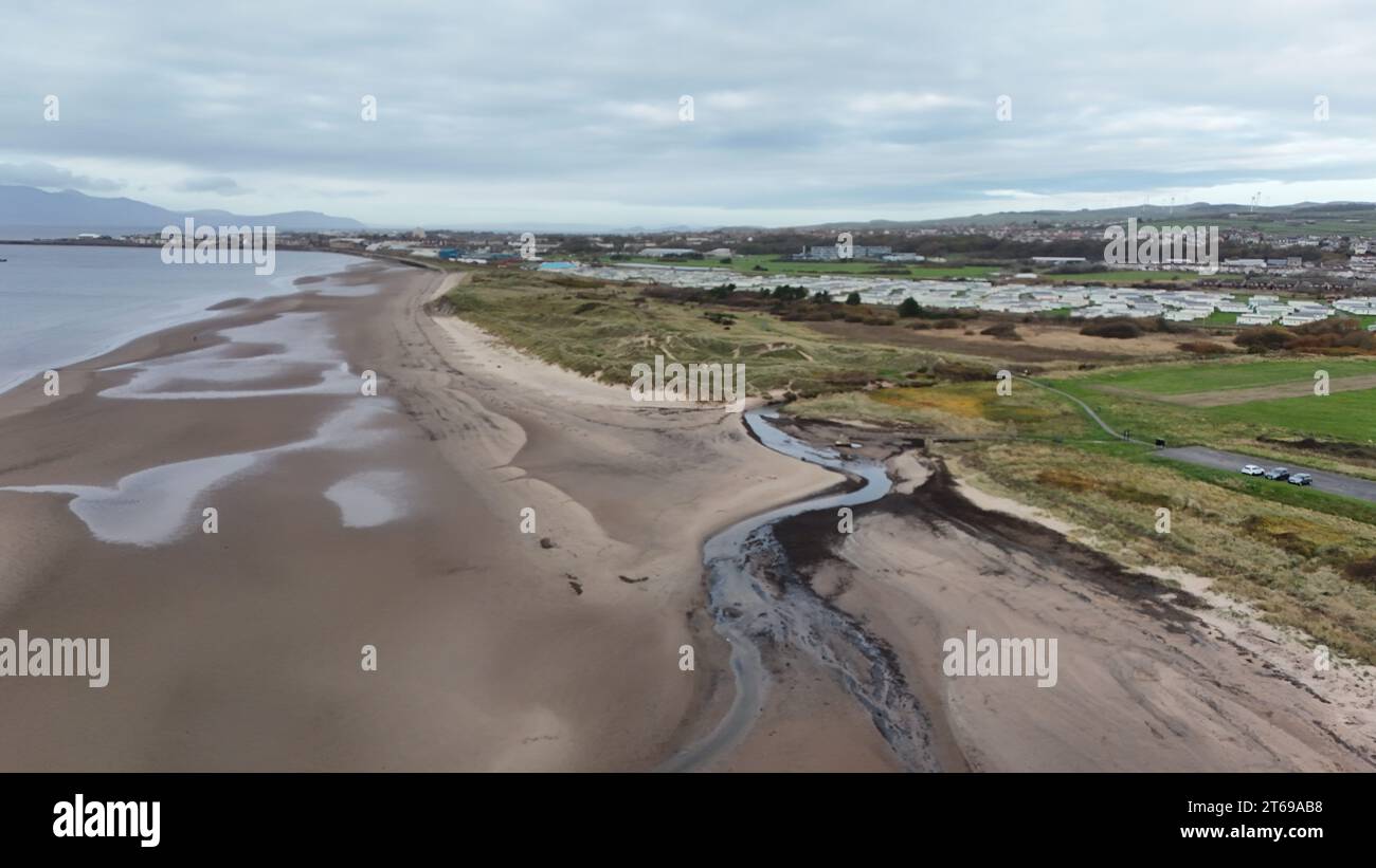 Un tranquillo ruscello scorre attraverso la spiaggia sabbiosa, creando un'atmosfera tranquilla Foto Stock