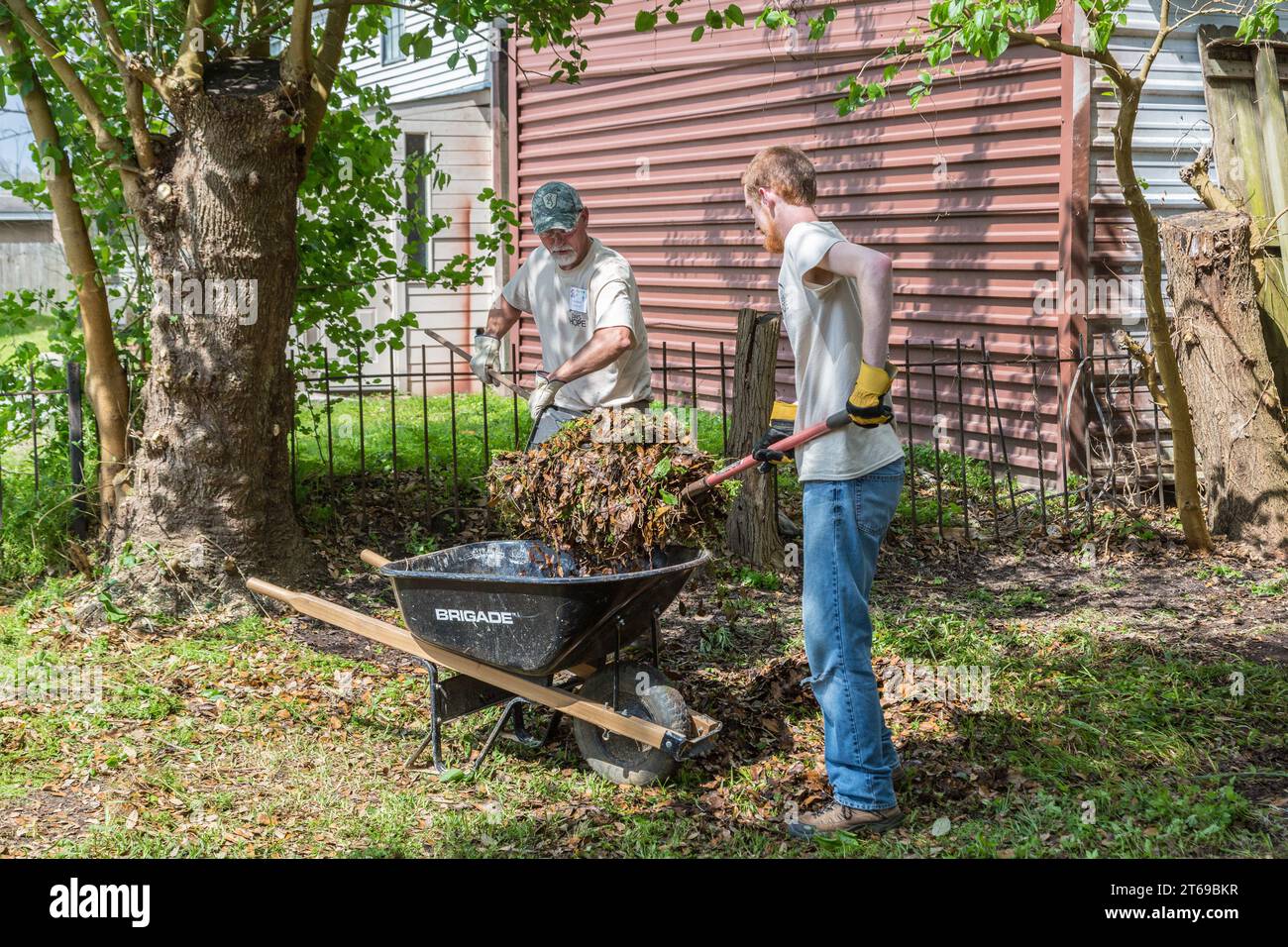 Membri di 8 giorni di squadra di volontari di beneficenza basata sulla fede Hope che pulisce il cortile di una casa che è stata allagata a Houston, Texas Foto Stock
