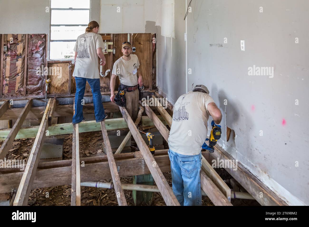 Membri di 8 giorni di volontariato di beneficenza basato sulla fede Hope che sostituiscono il pavimento di una casa che è stata allagata a Houston, Texas Foto Stock