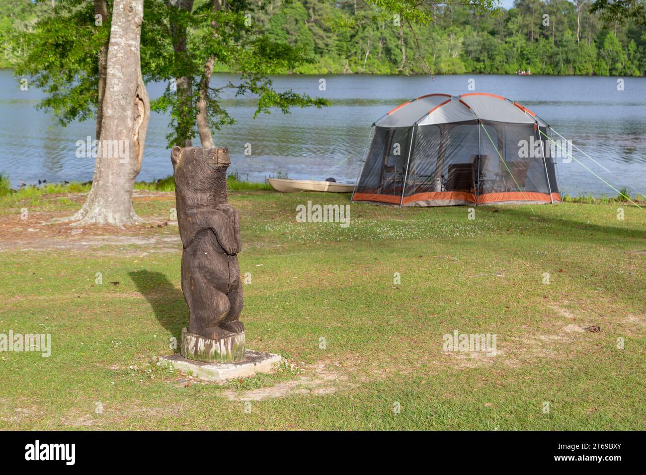 La motosega scolpisce un orso vicino a una tenda protetta lungo la riva del lago Geiger nel Paul B. Johnson State Park vicino a Hattiesburg, Mississippi Foto Stock