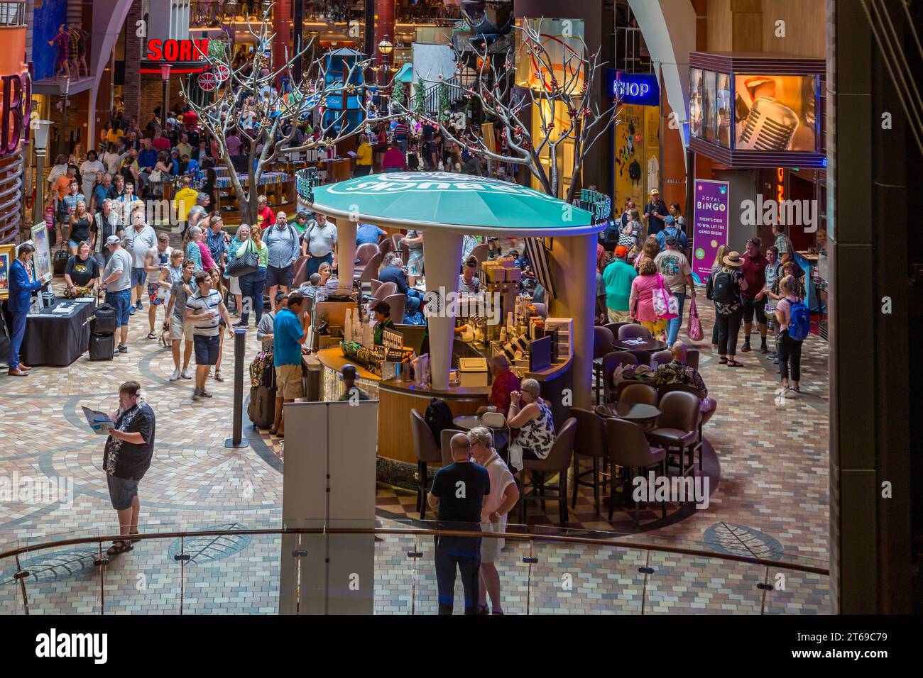 I passeggeri della crociera si riuniscono nell'area dei negozi della Promenade dopo essere saliti a bordo della nave da crociera Royal Caribbean Allure of the Seas. Foto Stock