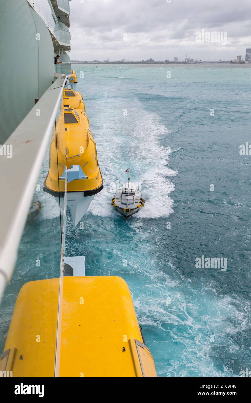 Posizionamento della barca pilota per ricevere il pilota del porto dalla nave da crociera Royal Caribbean Allure of the Seas nell'Oceano Atlantico al largo di Fort Lauderdale, Florida Foto Stock