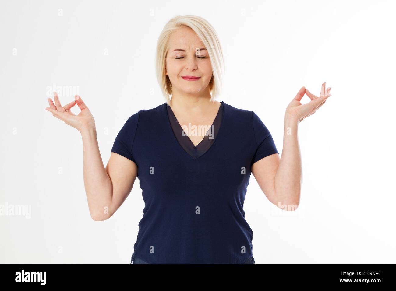 Donna bionda di mezza età su sfondo bianco isolato rilassarsi e sorridere con gli occhi chiusi facendo gesto di meditazione con le dita. Concetto di yoga. Calma po Foto Stock