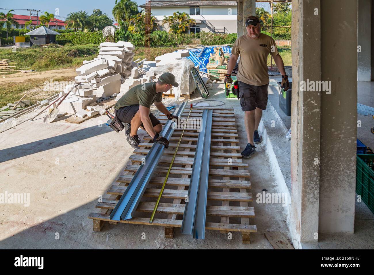 Uomini americani che preparano borchie di metallo mentre si offrono volontari per aiutare a costruire la Grace Language School e la Baan Athitaan Church a Chiang Rai, Thailandia Foto Stock