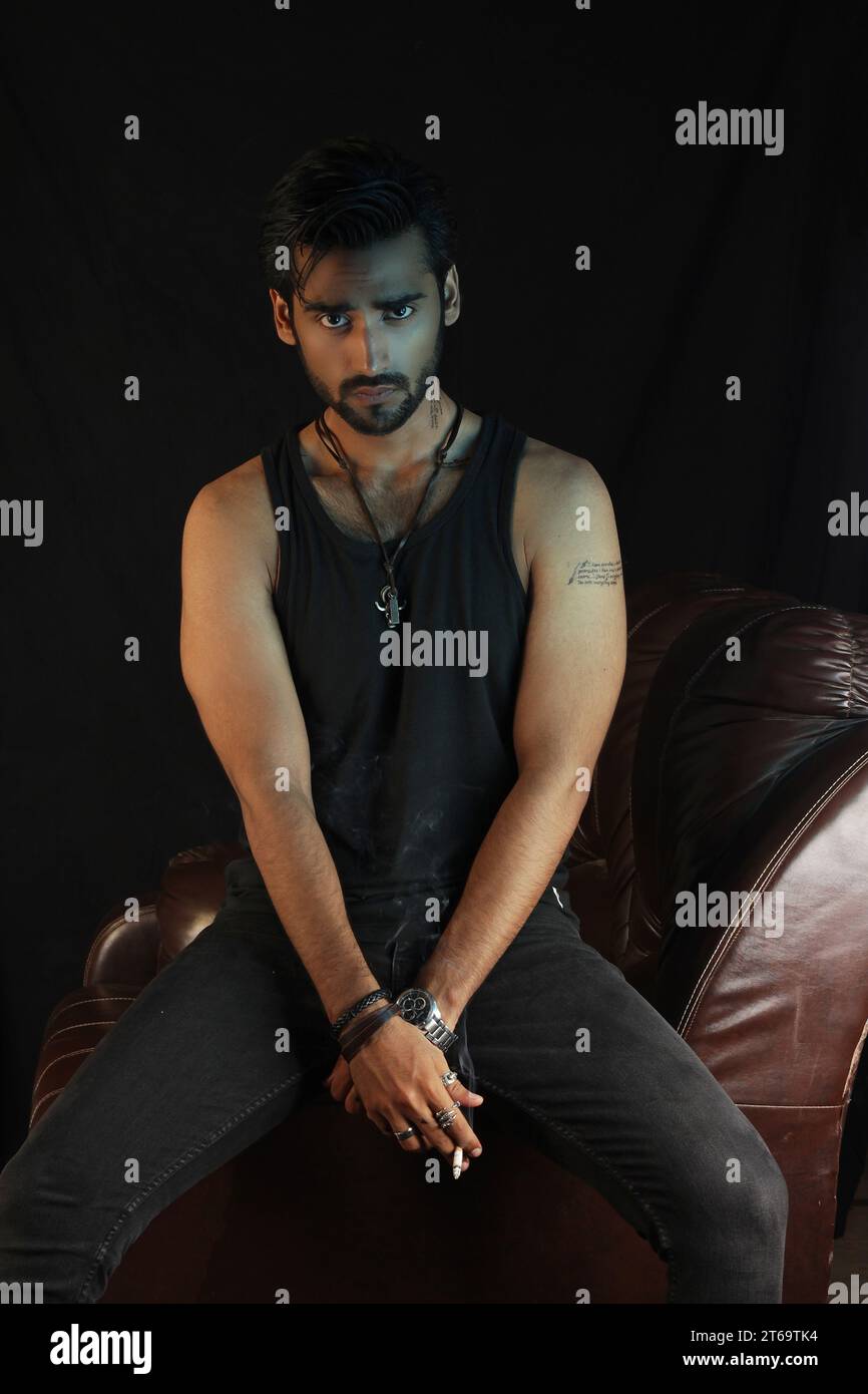 Bel giovane uomo che fuma sigaro e guarda lontano Foto Stock