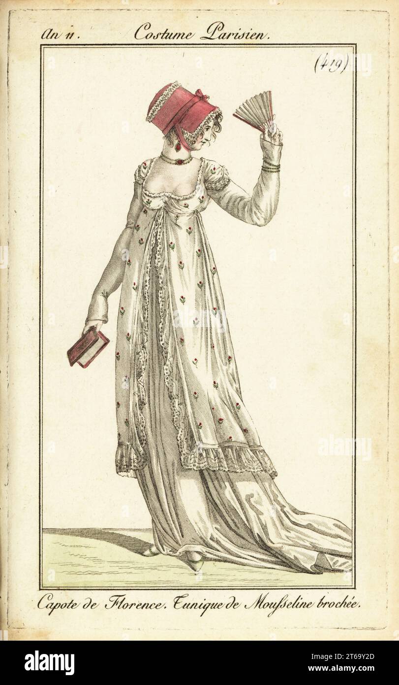 Donna alla moda con fan e almanacco. Indossa un cofano fiorentino con cappuccio, un abito in tunica di muslin broccato, una collana a girocollo. Capote de Florence. Brochée Tunique de Mousseline. Incisione in copperplate a mano da Pierre de la Mesangeres Journal des Dames et des Modes, Magazine of Women and Fashion, Paris, An 11, 1802. Illustrazioni di Carle Vernet, Jean-Francois Bosio, Dominique Bosio e Philibert Louis Debucourt, incise da Pierre-Charles Baquoy. Foto Stock