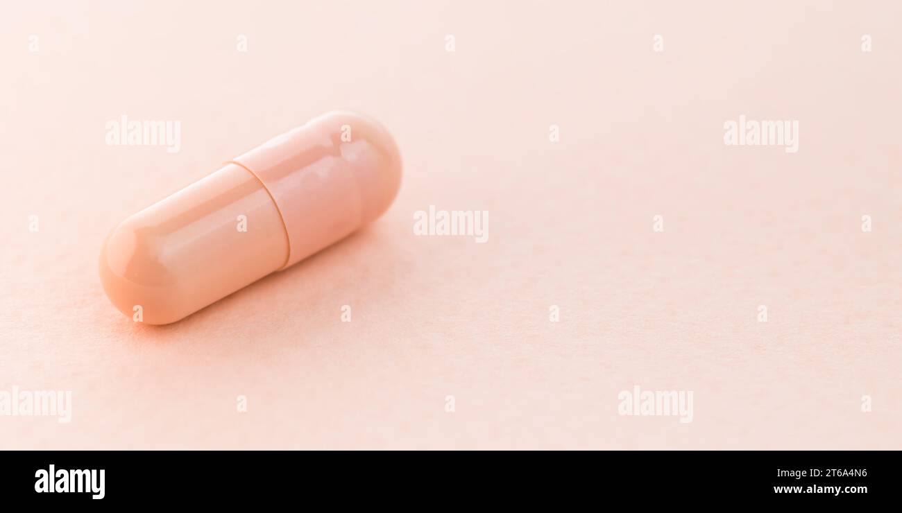 Closeup pillola medica o compressa su sfondo rosa con spazio di copia. Modello di capsule pillole. Concetto di farmacia medica e ospedale sanitario. Foto Stock