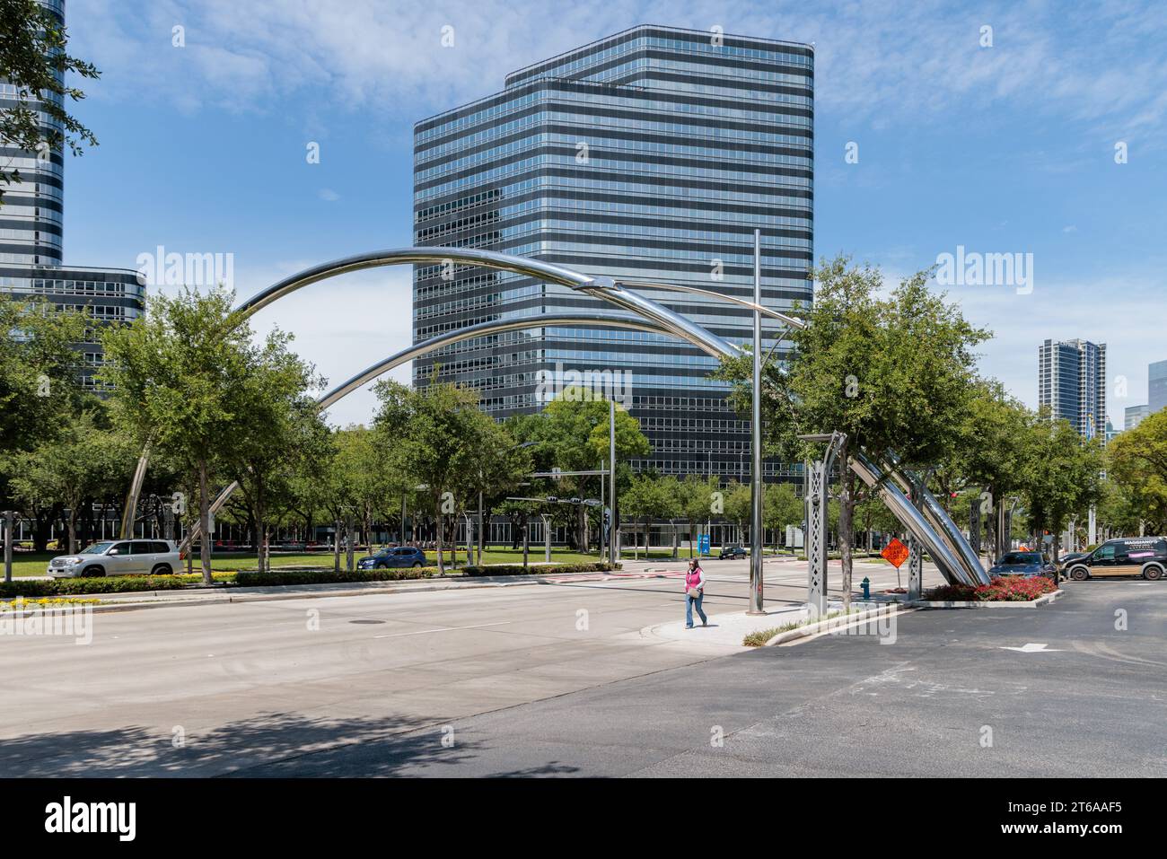 Passeggia davanti ad archi in acciaio cromato che attraversano Post Oak Boulevard nel centro di Houston, Texas Foto Stock