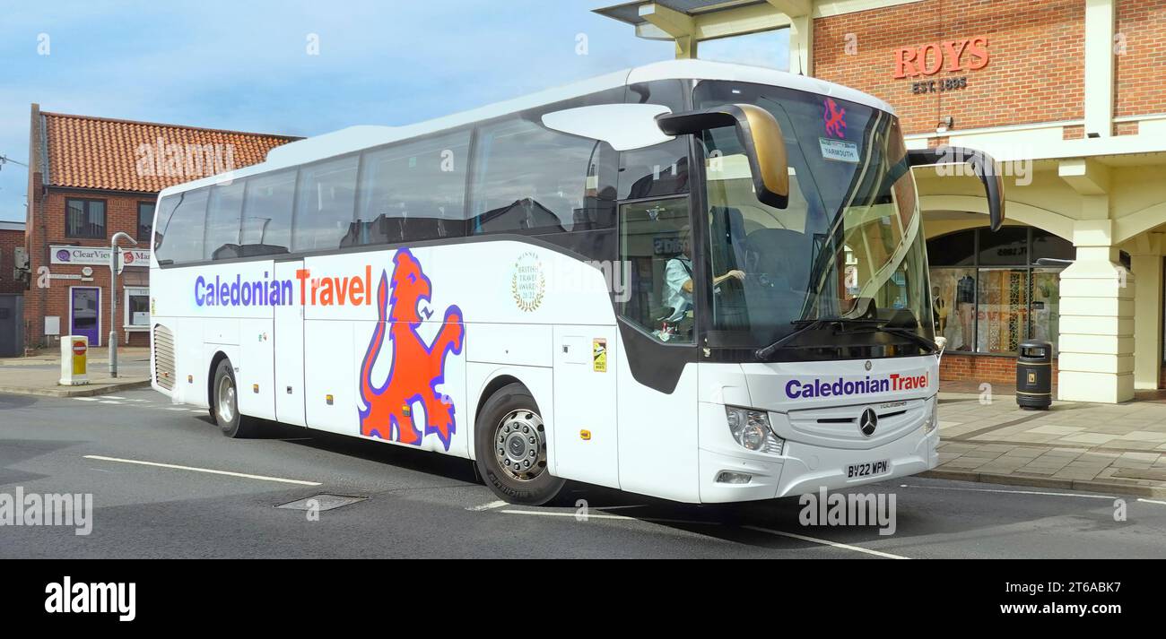 Caledonian Travel, tour di affari, nome di marca, logo Scottish Lion, viste frontali laterali, autista di pullman Mercedes che naviga a Wroxham, Norfolk, Regno Unito Foto Stock