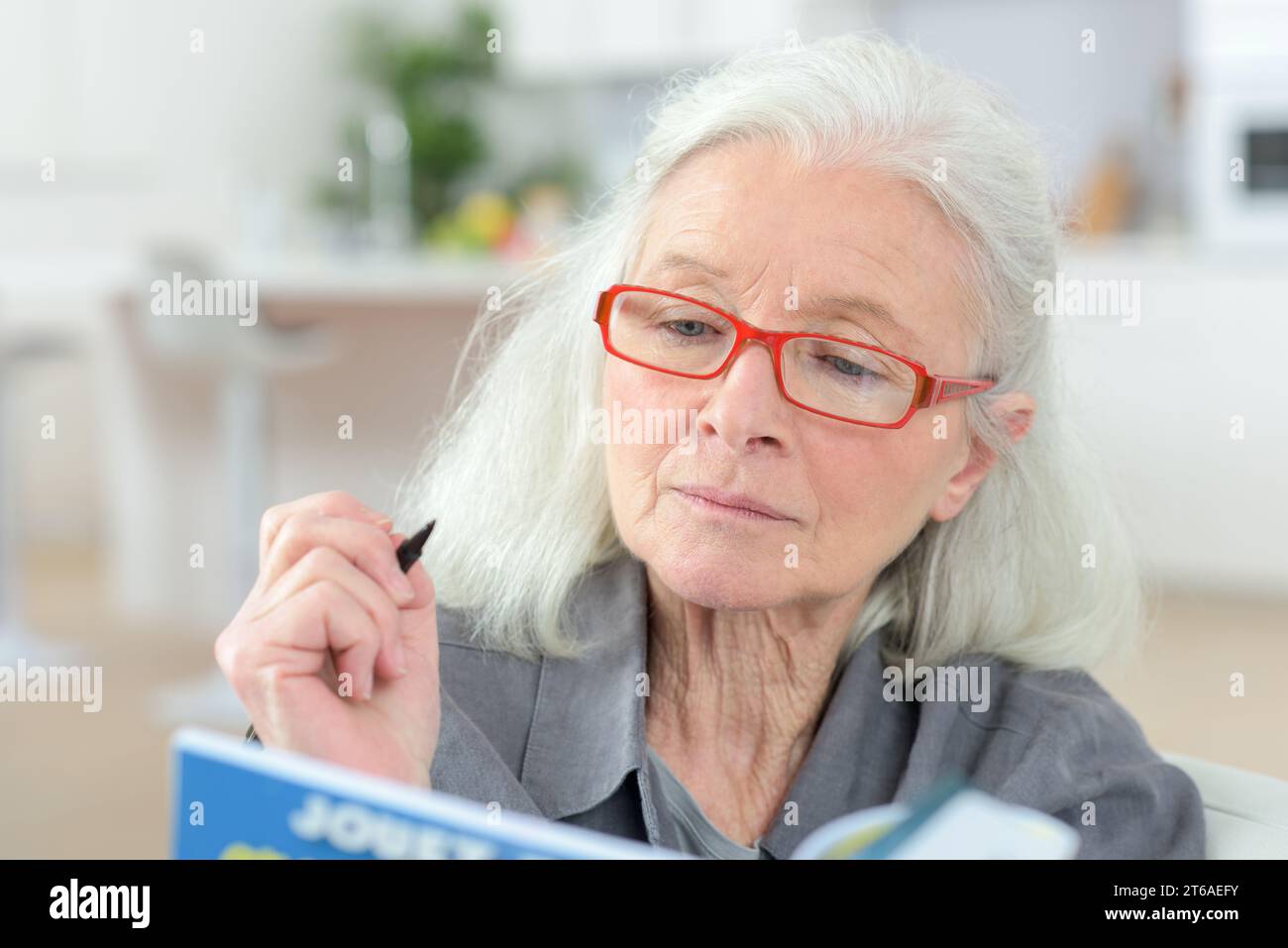 donna anziana che calcola le tasse a casa Foto Stock