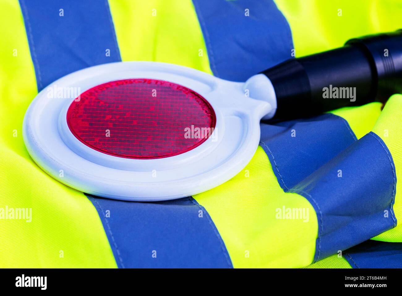 controllore del traffico cop. traffico di pagaia rossa. Lo strumento, soggetto alla regolazione del traffico. primo piano. Il concetto di sicurezza stradale Foto Stock