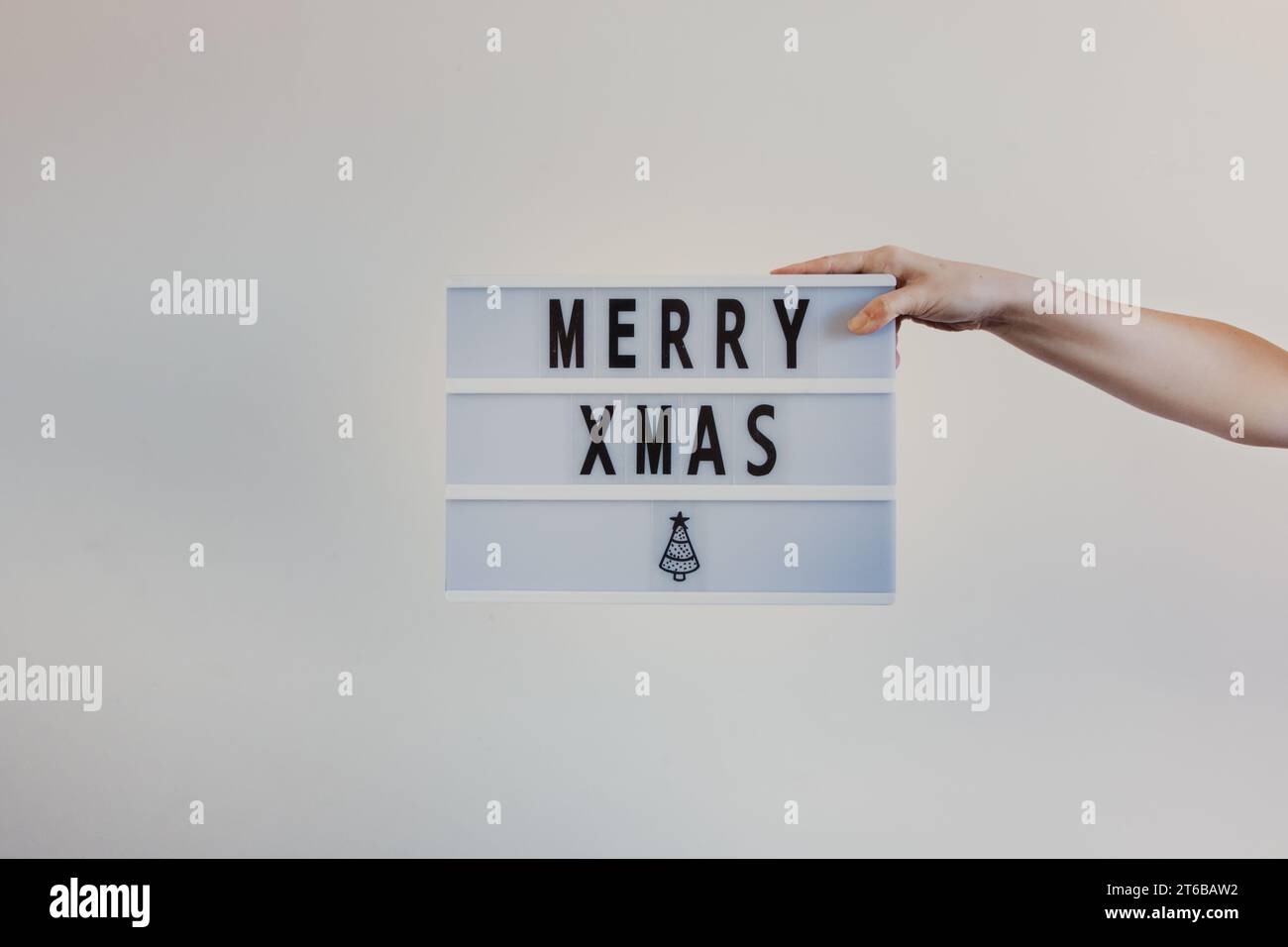 con in mano un semplice cartello di buon natale Foto Stock