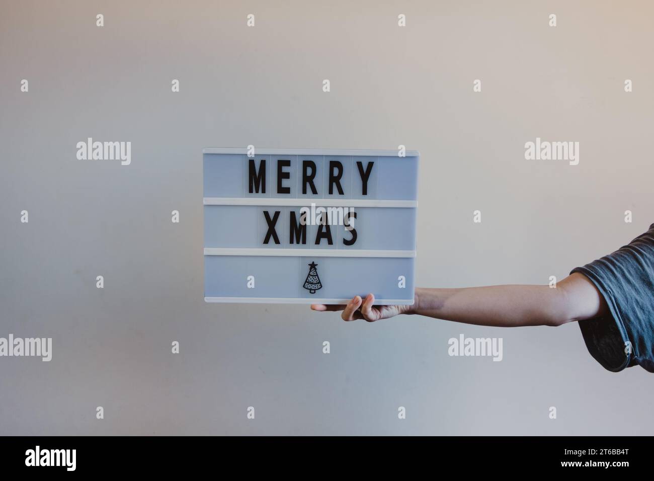persona che tiene in mano un cartello di natale allegro Foto Stock