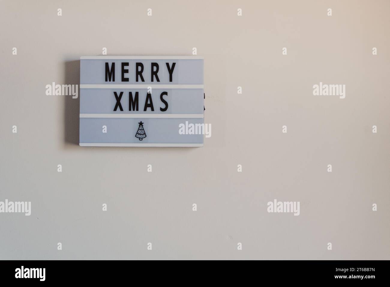 un semplice cartello di buon natale nel copyspace del muro Foto Stock