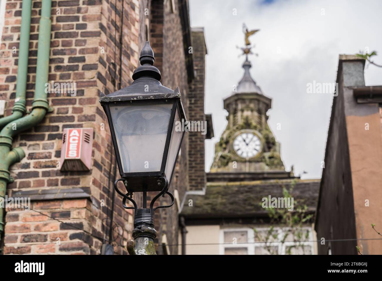 Burslem, Stoke on Trent, Inghilterra, 21 marzo 2023. Lampione tradizionale contro la torre dell'orologio con una paletta resistente agli agenti atmosferici, illustrazione di viaggio editoriale. Foto Stock