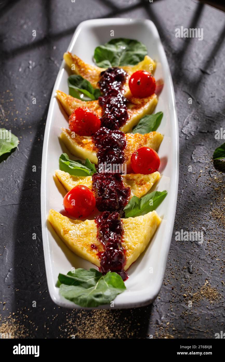 Papialpa grigliata con marmellata di frutta rossa con pomodori ciliegini e basilico Foto Stock