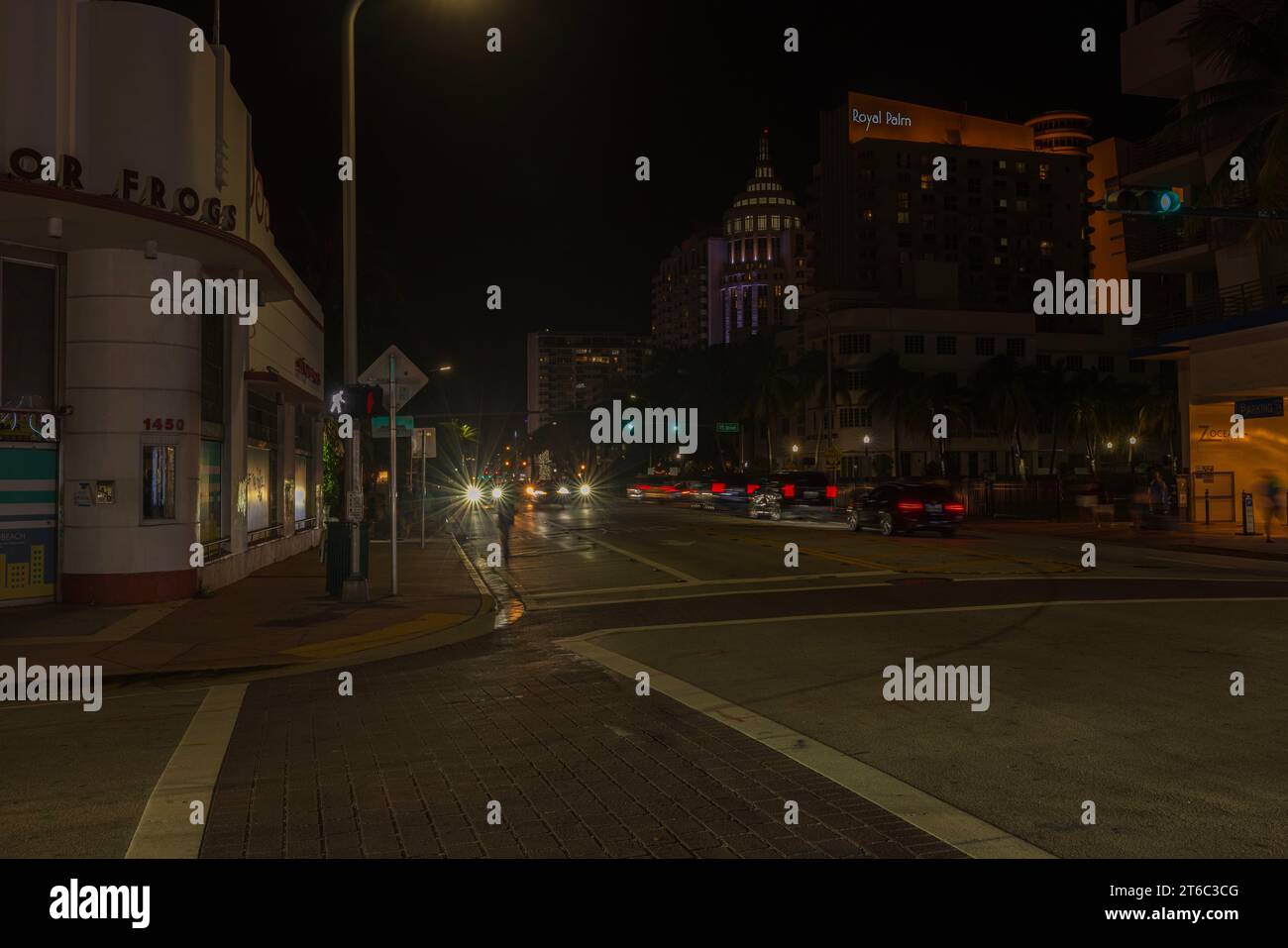 Splendido paesaggio urbano notturno di Miami Beach Street illuminato dalle luci delle auto di passaggio, che proiettano vibranti bagliori sui dintorni. Miami Beach. USA. Foto Stock