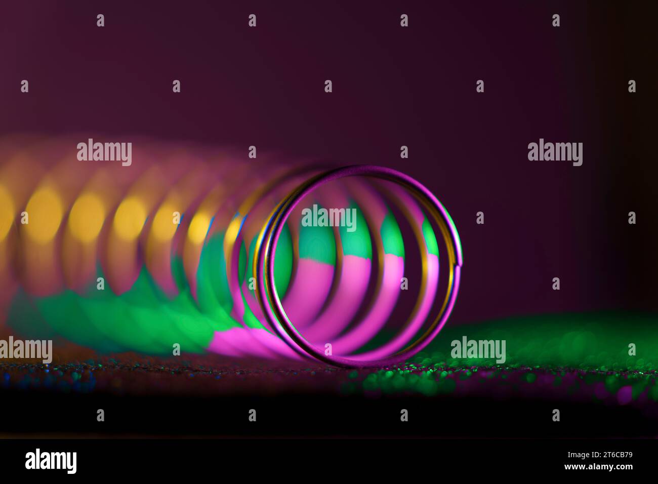 Una macro vista angolare multicolore di una molla che mostra il suo design tubolare a spirale. Foto Stock