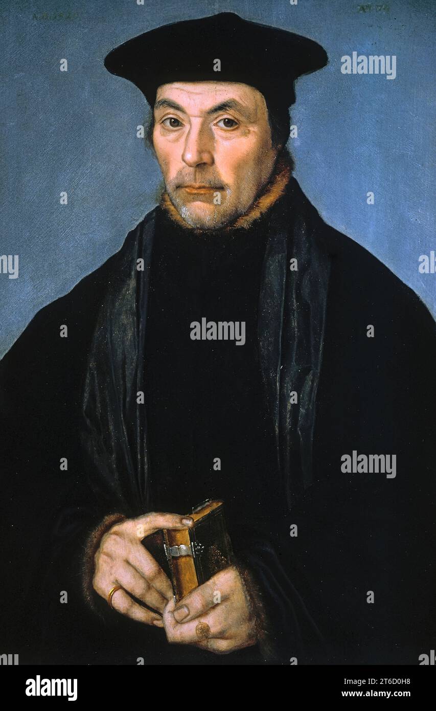 Ritratto di uno studioso o predicatore, 1529. Il cappello è di un tipo indossato da studiosi e predicatori, tra gli altri, e il piccolo libro che la babysitter tiene potrebbe essere un'opera devozionale o, se è uno studioso, una sua pubblicazione. Un mantello rivestito di pellicce non era un lusso: Le case erano scarsamente riscaldate in inverno, e tutti si vestivano calorosamente all'interno, soprattutto se seduti per lunghi periodi. La mano della babysitter sembra essere intenzionalmente presentata come deformata. In questo periodo, le deformità erano generalmente viste come un segno di sfavore divino. L'inclusione di questa mano può essere il modo del sitter di segnalare la sua accettazione Foto Stock