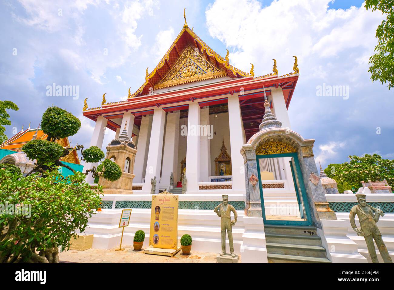 Vista esterna dell'incombente tempio con alte colonne bianche. A Phra Ubosot Wat Suthat a Bangkok, Thailandia. Foto Stock
