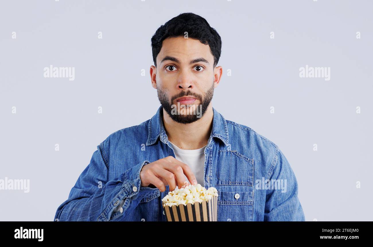Televisione, ritratto e uomo con popcorn in studio per film, film o documentari su sfondo grigio. Cinema, guardare la tv e il volto del modello con Foto Stock