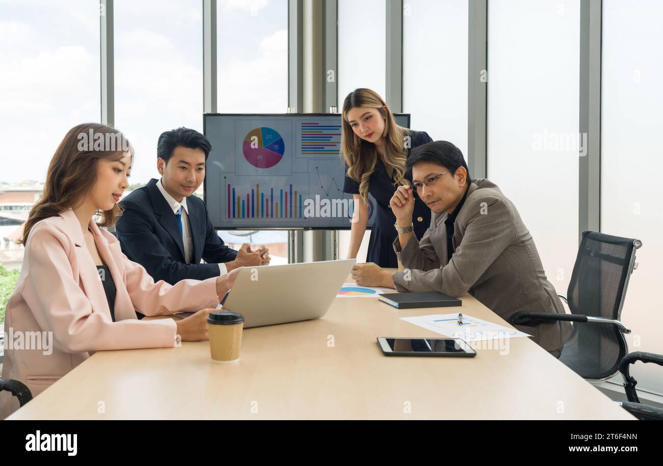 Professionisti aziendali altamente qualificati che discutono piani strategici e prendono decisioni a un tavolo da conferenza in un ufficio professionale. Foto Stock