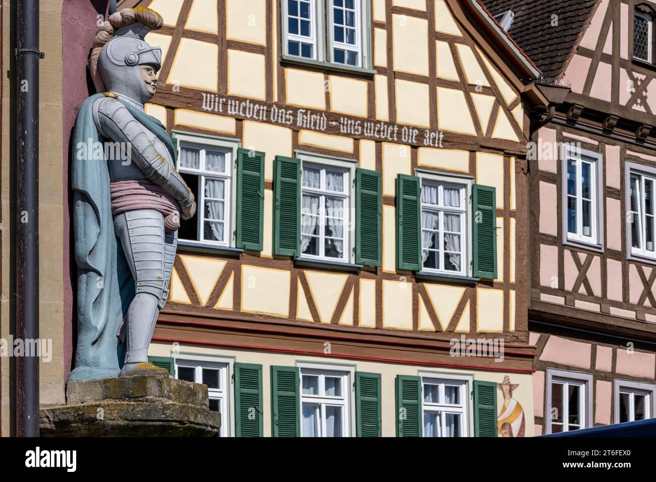 Scultura medievale di cavalieri sulla facciata di un angolo di casa, di fronte al Ponte dell'Hangman, con armatura, casco e spada e case in legno Foto Stock