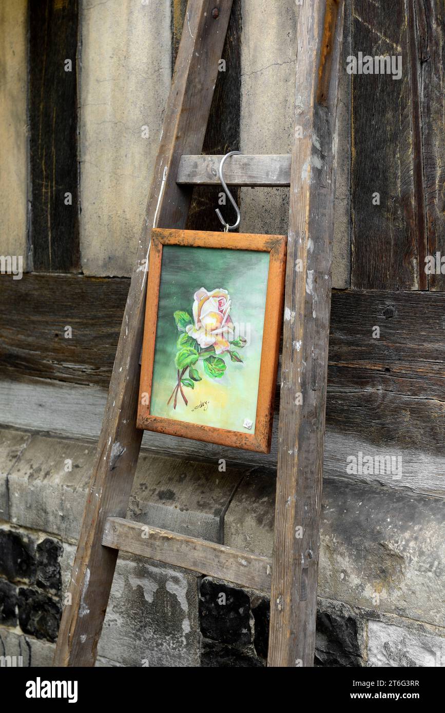 Vecchio dipinto incorniciato esposto su una vecchia scala a gradini di legno in un mercato delle pulci, Brocante, Place Sainte Catherine, Honfleur, Normandia, Francia Foto Stock