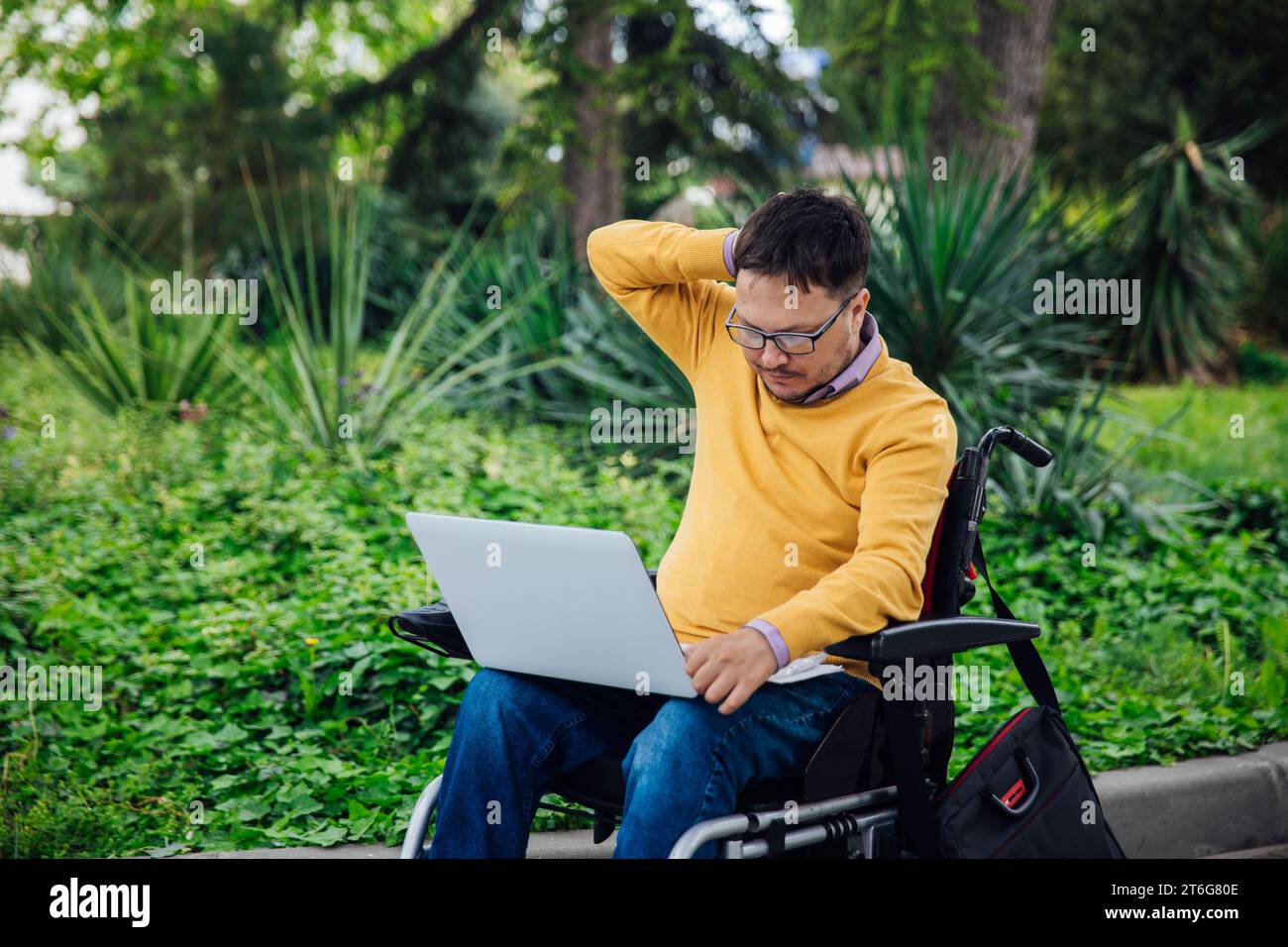 Una persona con un computer portatile nel parco Foto Stock