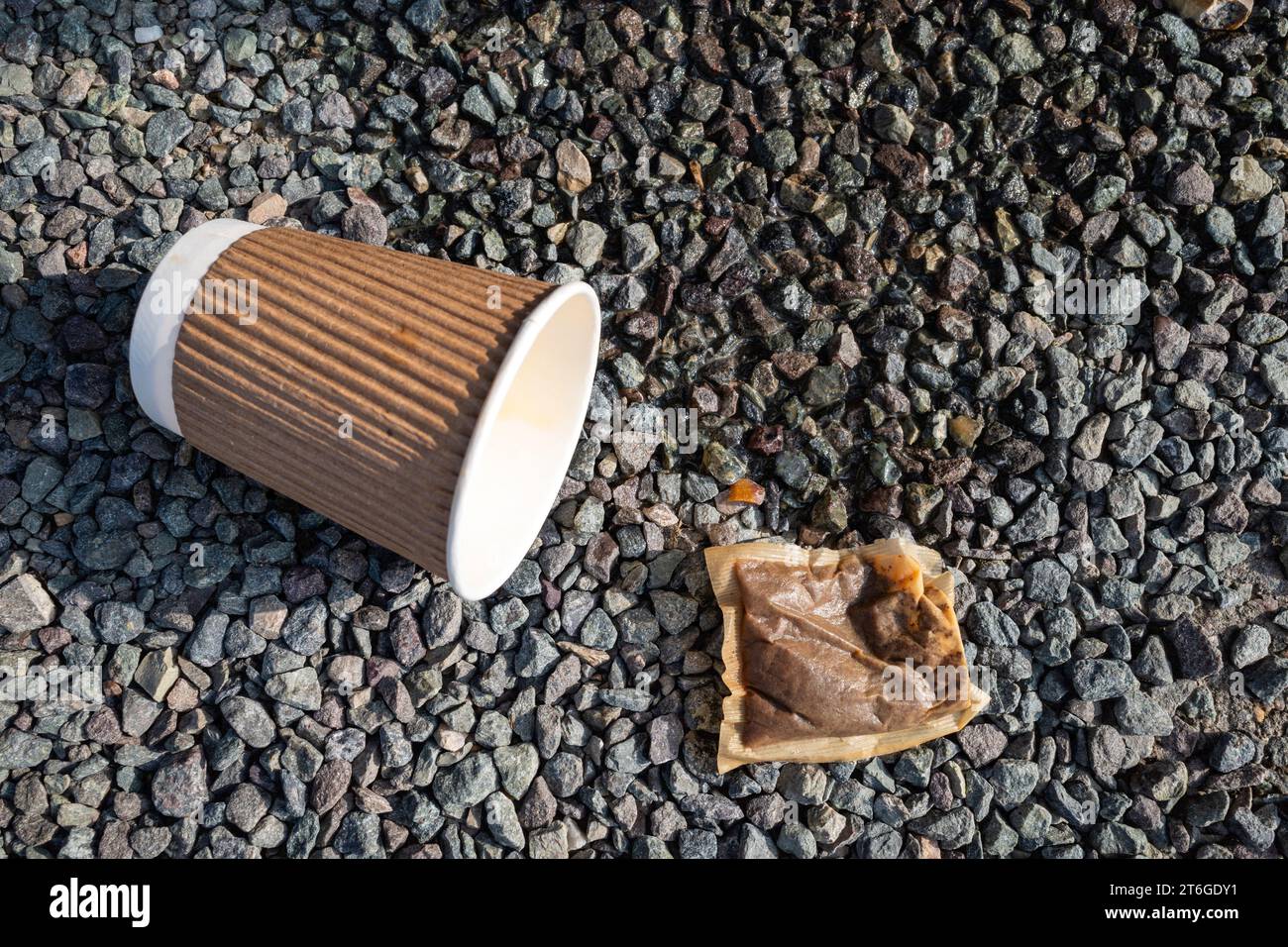 Tazza vuota e bustina di tè in posa su una strada Foto Stock