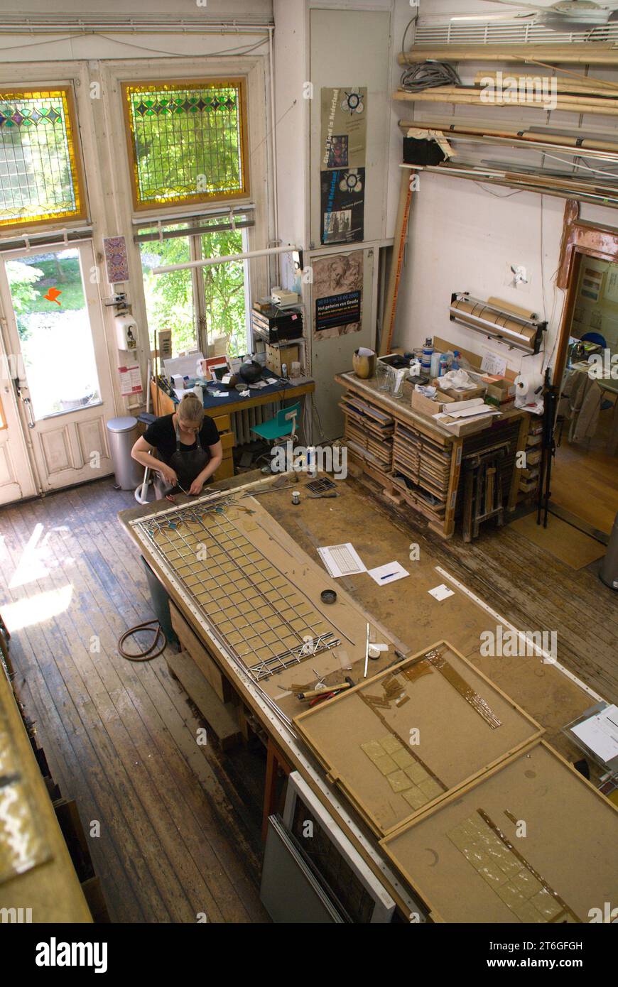 Groningen, Paesi Bassi, 05-25-2009. Studio in vetro Ballast e Bonekamp. Un dipendente lavora nello studio di vetrate colorate. Foto Stock