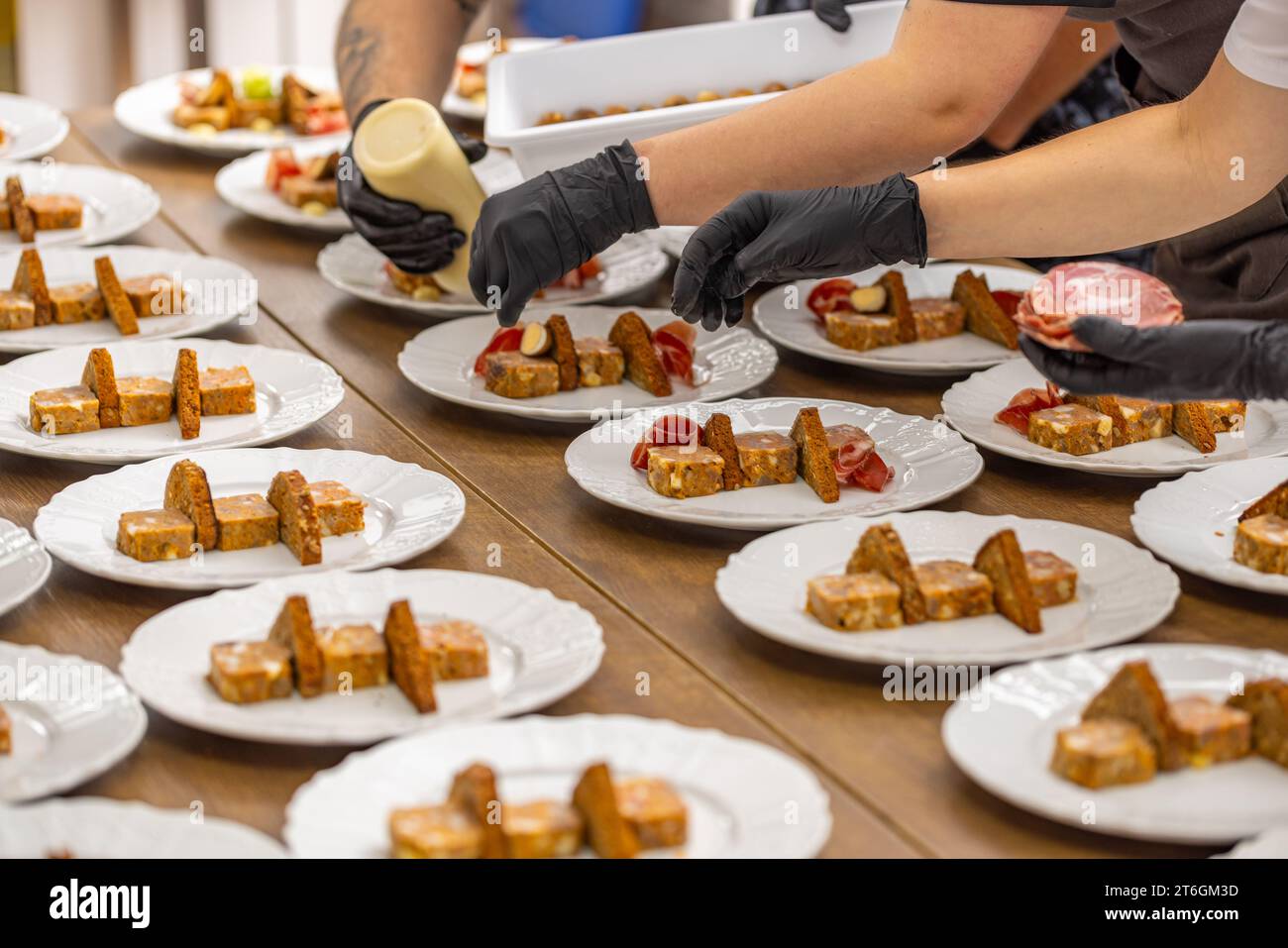 La scena racchiude l'arte della presentazione culinaria in un ambiente da cucina professionale. Foto Stock