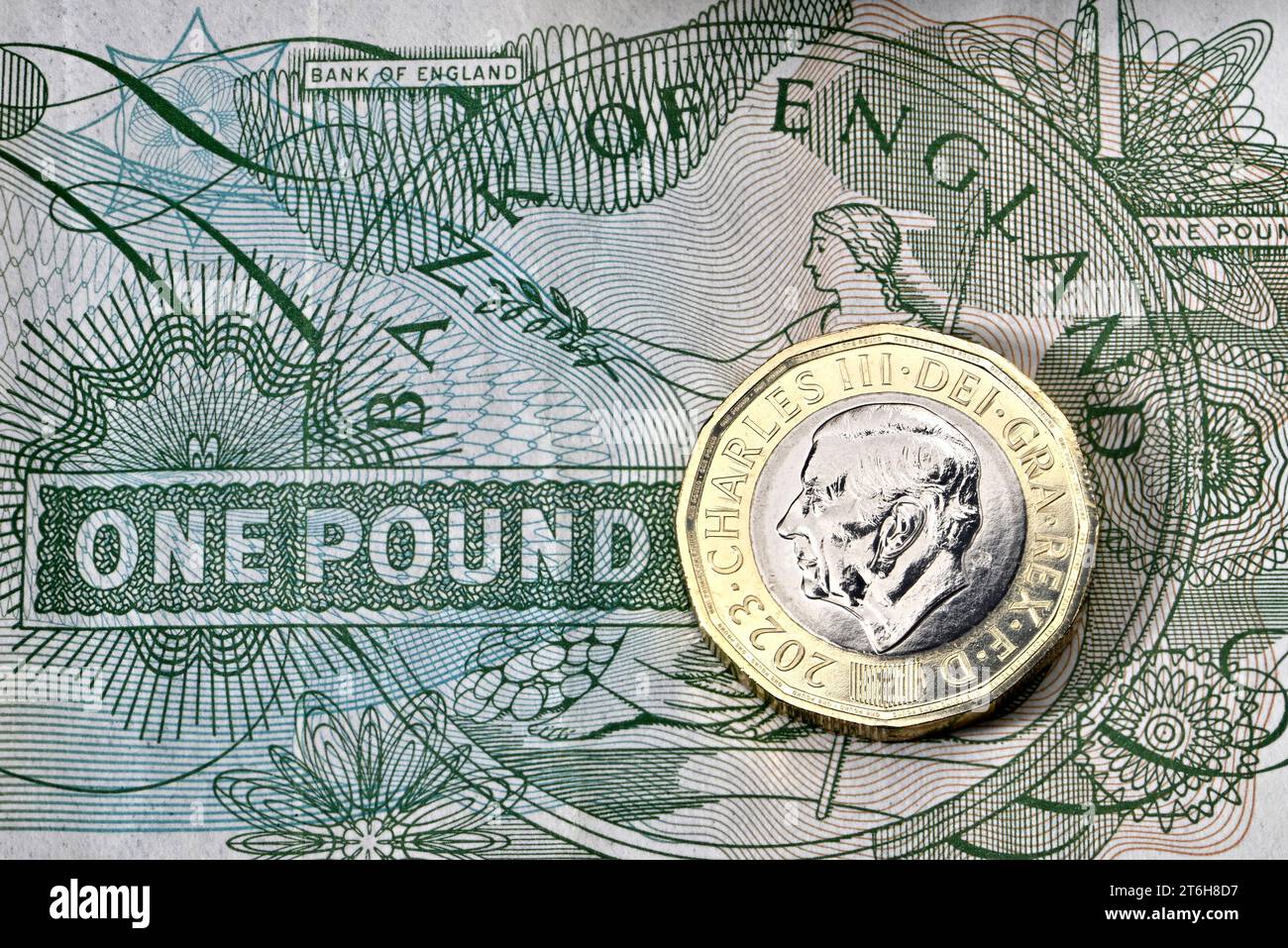 Una moneta da £1 del britannico Charles III su una vecchia banconota da sterlina Foto Stock