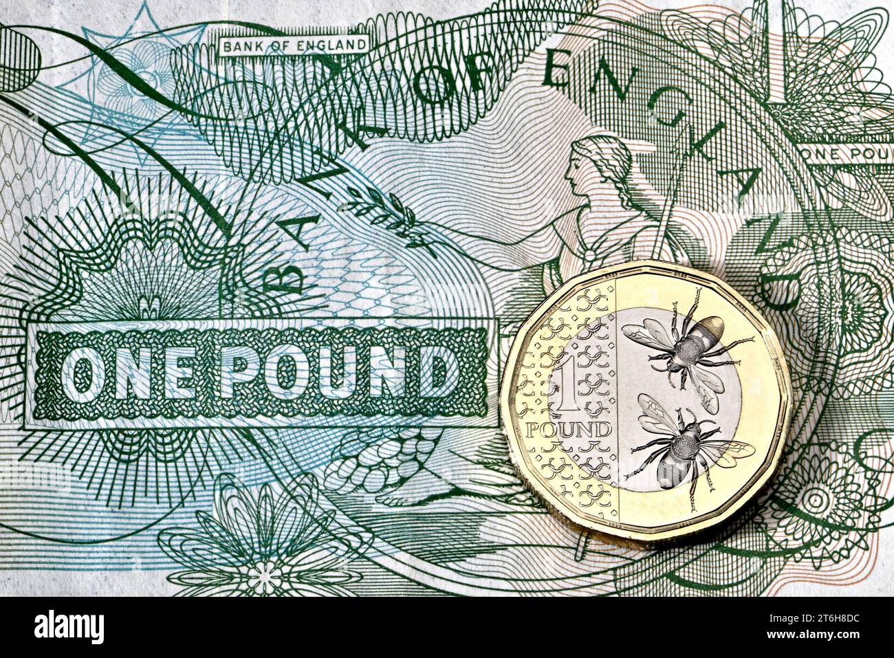 Una moneta da £1 del britannico Charles III su una vecchia banconota da sterlina Foto Stock