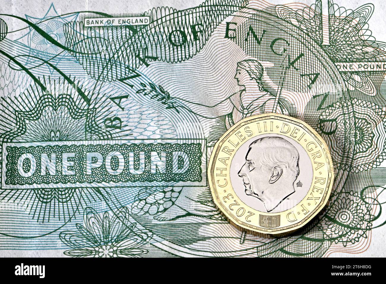 Una moneta da £1 del britannico Charles III su una vecchia banconota da sterlina Foto Stock