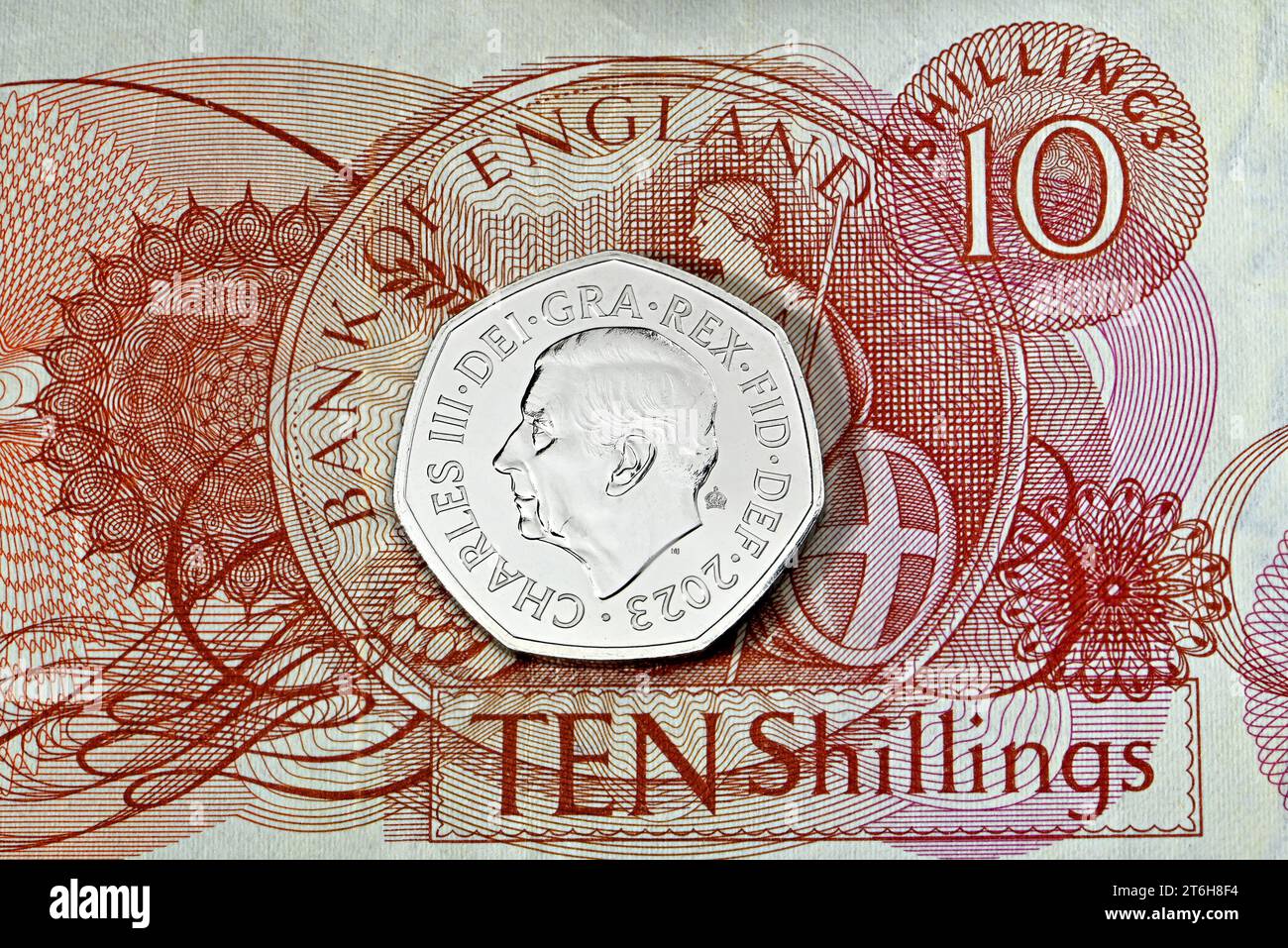 Moneta britannica Charles III 50p su una vecchia banconota da 10 scellini Foto Stock