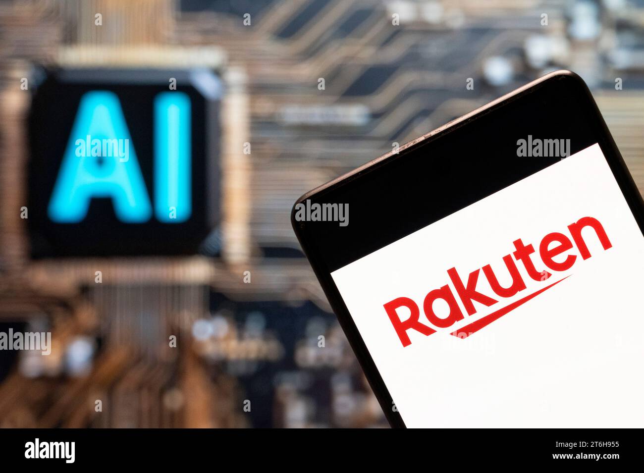 In questa foto, il logo della società giapponese di commercio elettronico e Internet Rakuten è visibile su uno smartphone con un chip e un simbolo di intelligenza artificiale (ai) sullo sfondo. Foto Stock