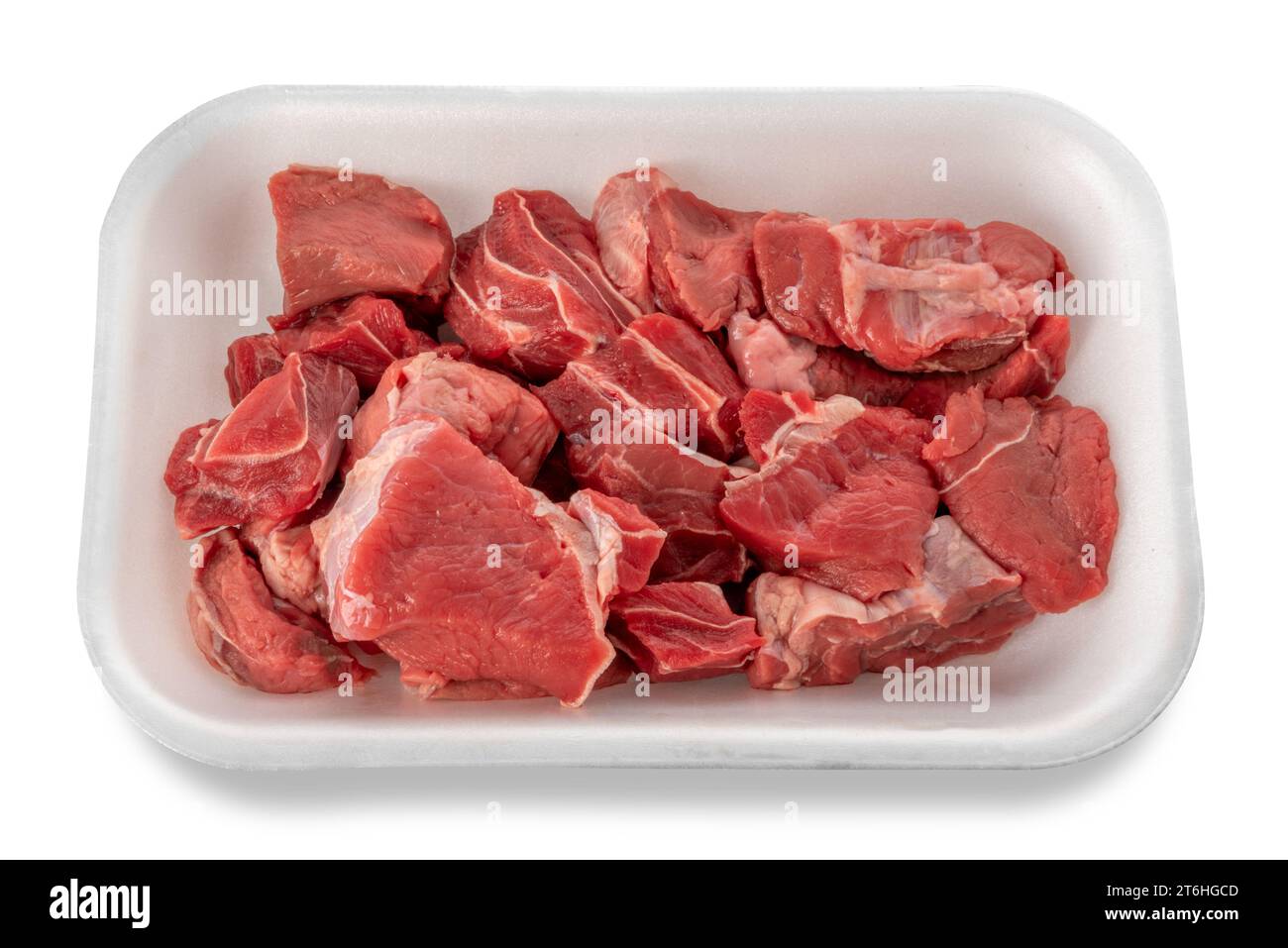 Carne di manzo rossa cruda a cubetti per goulash o stufato crudo in vassoio di plastica per uso alimentare Isolato su sfondo bianco. Tracciato di ritaglio incluso Foto Stock