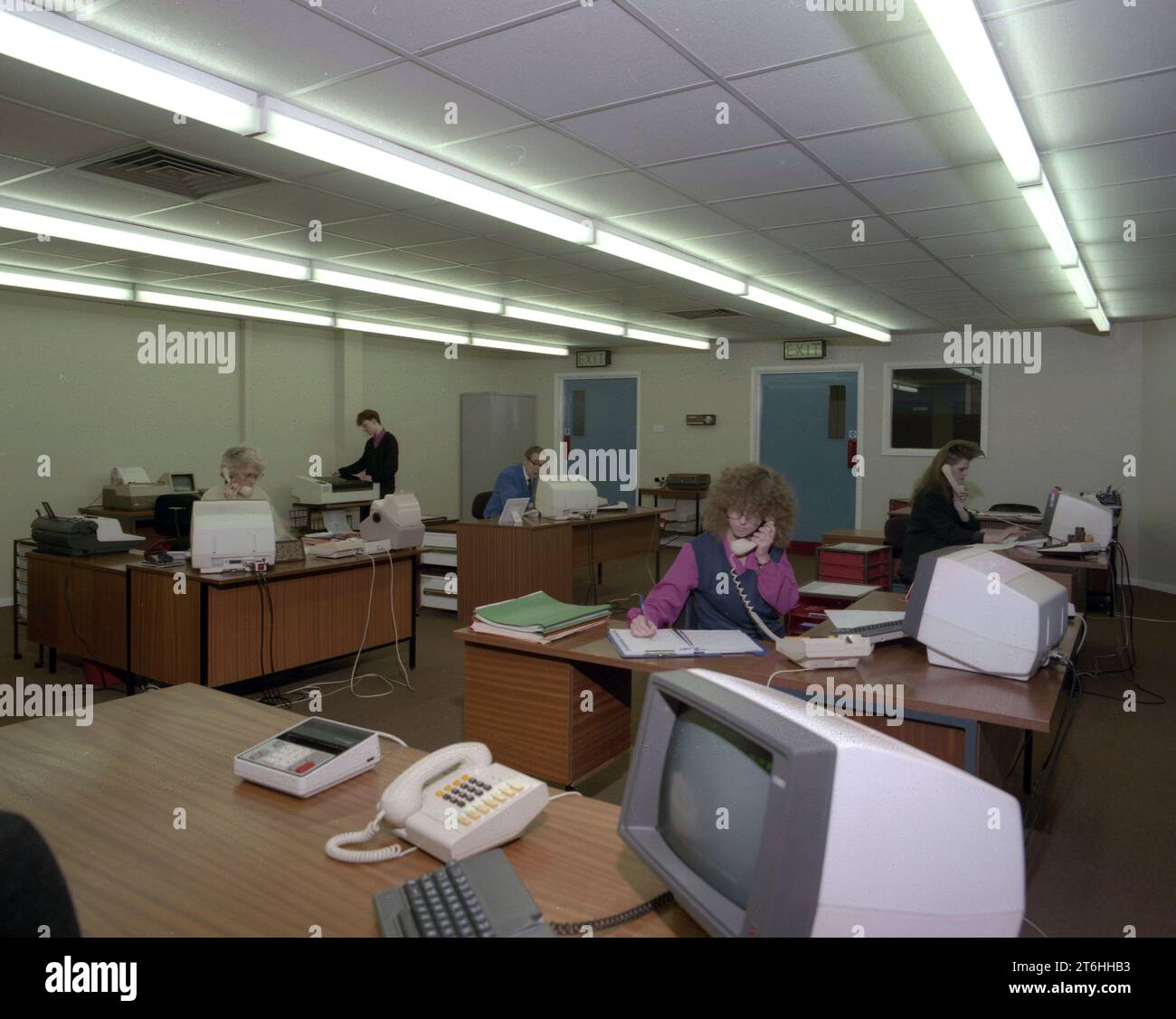 Alla fine degli anni '1980, personale femminile che lavorava in un ufficio open space, molti al telefono, con terminali informatici dell'epoca sulle scrivanie, Inghilterra, Regno Unito. Foto Stock