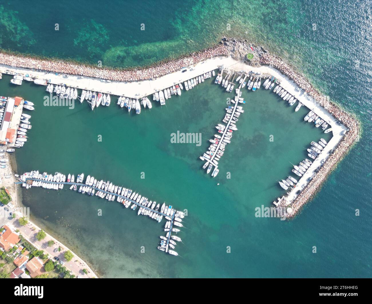 Un ambiente tranquillo di un porticciolo, caratterizzato da una varietà di barche ormeggiate nelle tranquille acque blu, che offrono un'atmosfera tranquilla Foto Stock