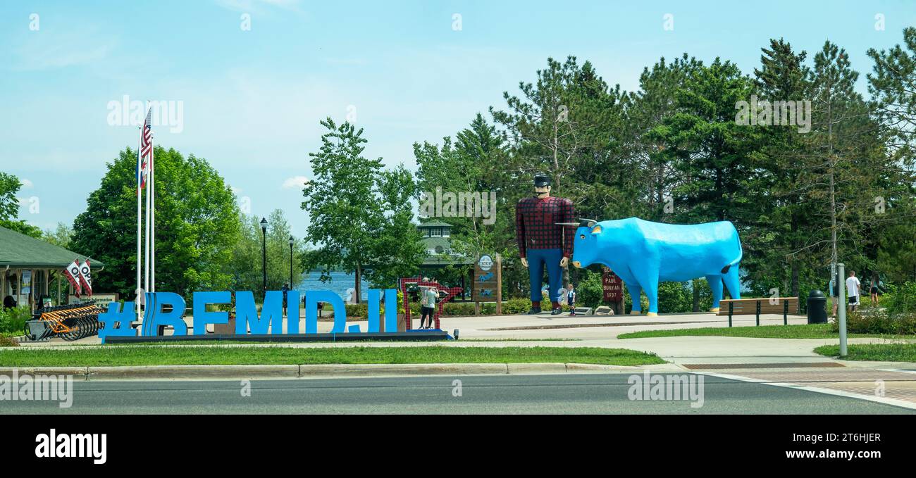 BEMIDJI, Minnesota - 3 giugno 2023: Statua di Paul Bunyan e Babe the Blue Ox, una popolare attrazione lungo la strada e un cartello blu lungo la strada. Foto Stock