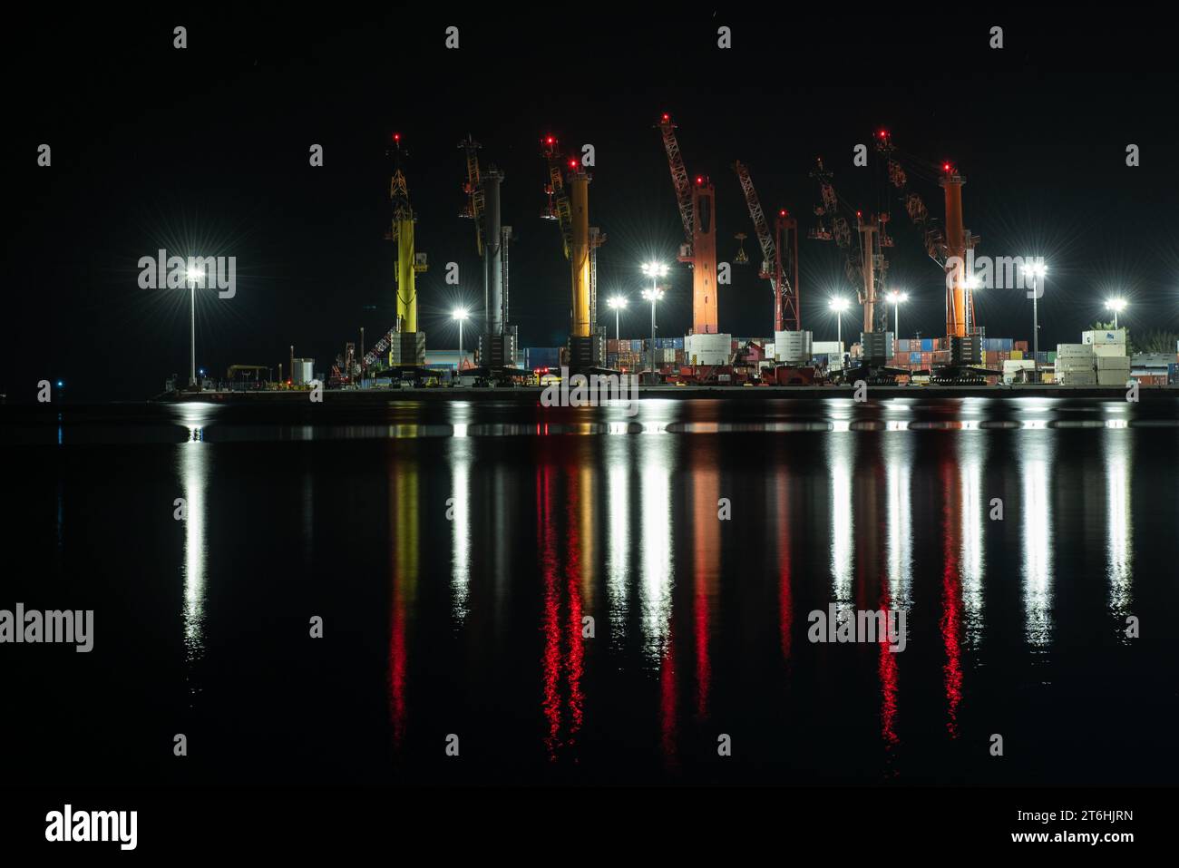 Porto di Papeete di notte con gru che scaricano navi portacontainer, Tahiti Foto Stock
