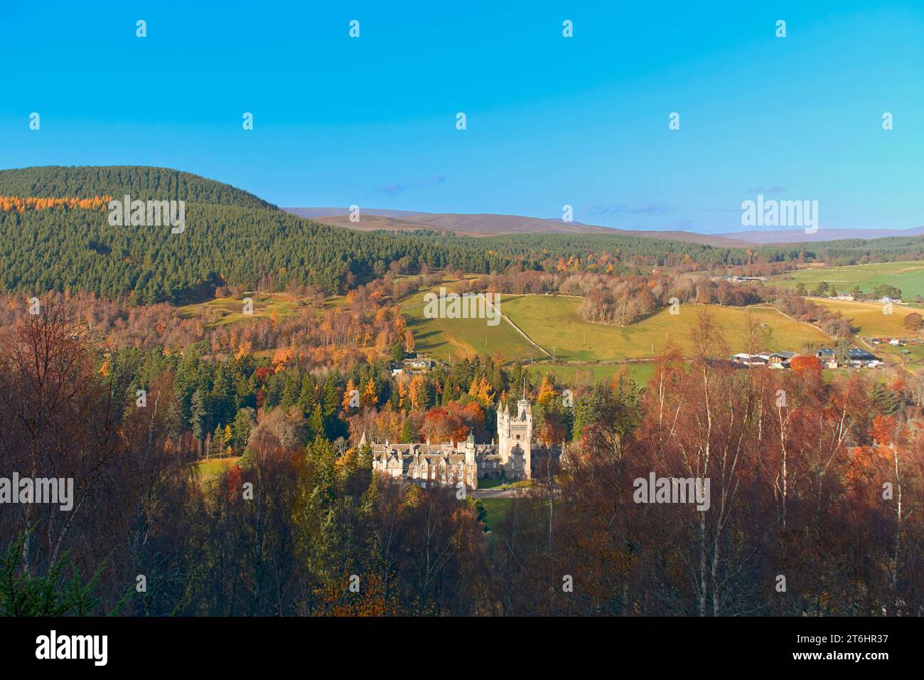 Balmoral Estates Crathie Scozia, sole autunnale sul castello, fattorie sparse e campi, tutti circondati da alberi autunnali colorati Foto Stock