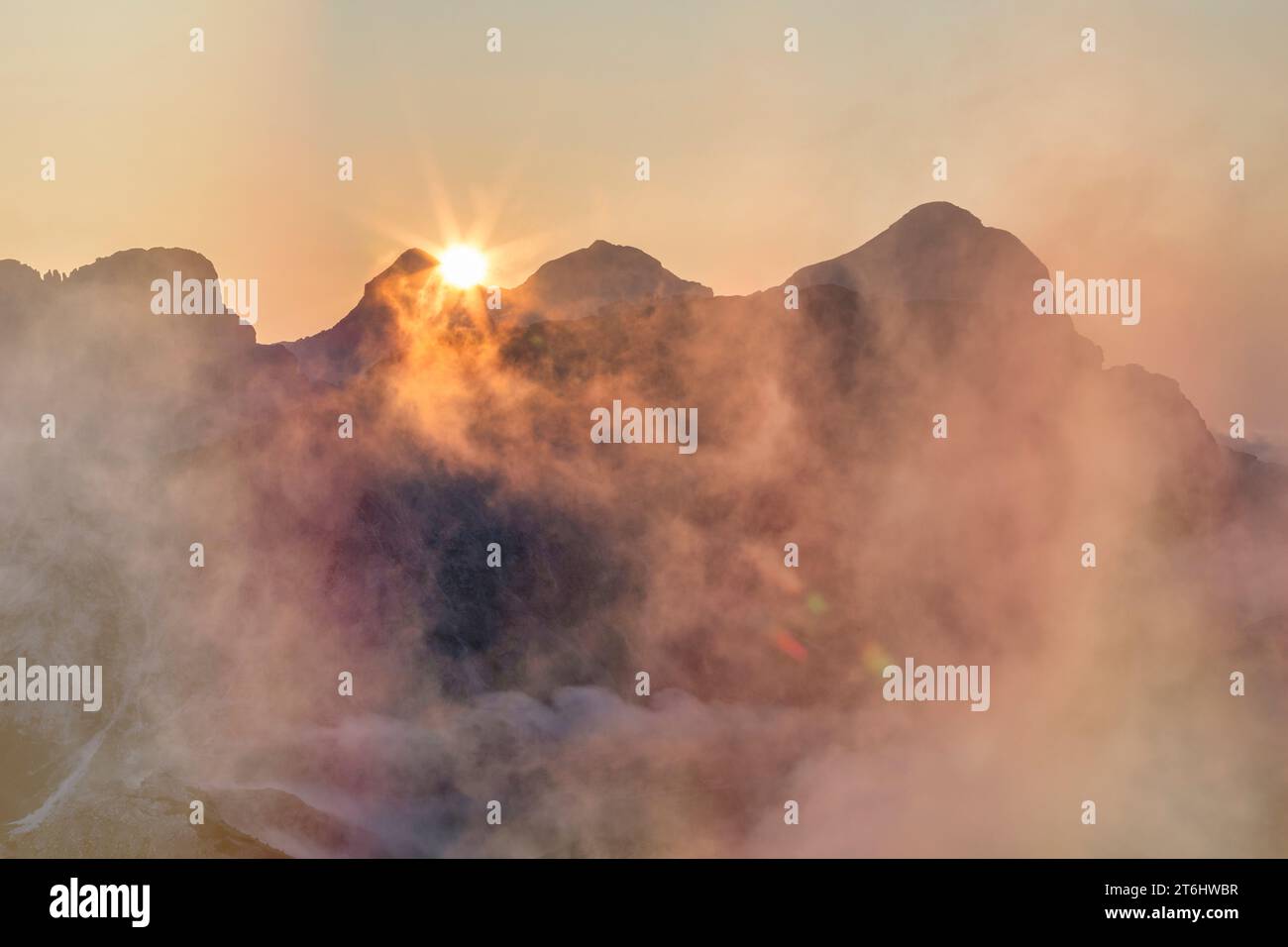 Italia, Veneto, provincia di Belluno, il sole sorge dietro la Tofane (Tofana di Rozes a destra), in primo piano all'ombra del Lagazuoi, Dolomiti Foto Stock