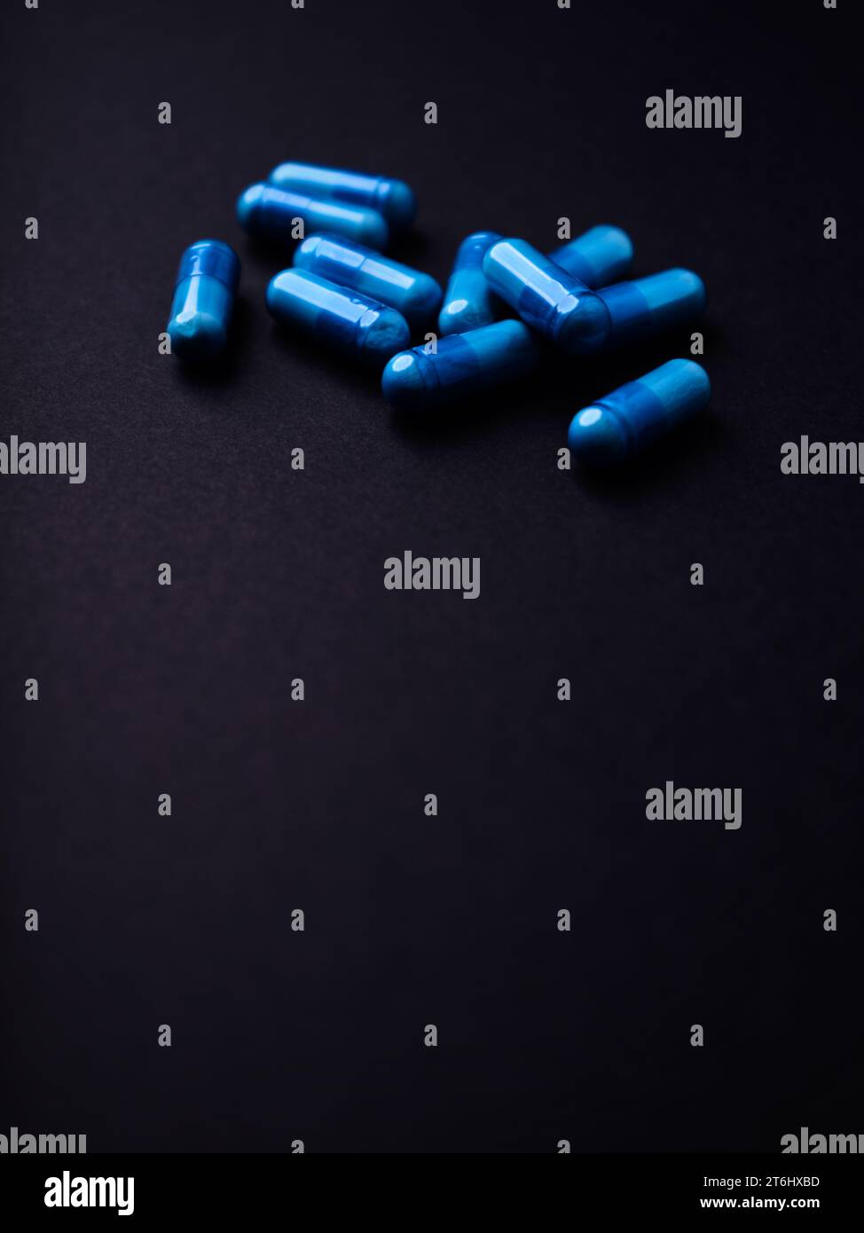 Capsule di aminoacidi su sfondo di carta scura. Messa a fuoco morbida. Primo piano. Copia spazio. Foto Stock