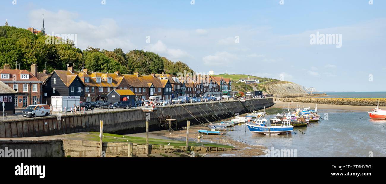 Folkestone, Kent, regno unito 1 agosto 2023 fila di case in mattoni rossi e barche a vela attraccate sul lungomare di Folkestone Foto Stock
