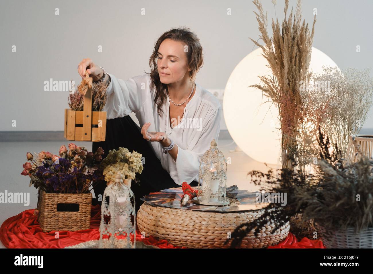 Circolo femminile e pratica nell'uso di carte metaforiche. La ragazza è seduta circondata da fiori. Foto Stock